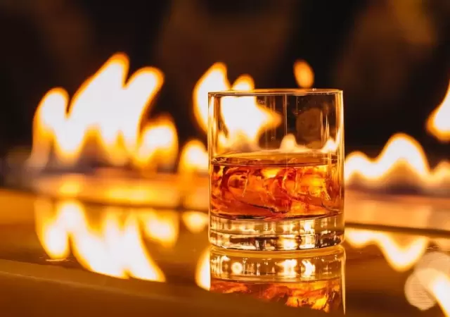 vista-lateral-vaso-whisky-hielo-sobre-fondo-llama-ardiente-jpg.