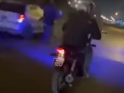 Captura de pantalla del video filmado desde una moto desde donde le gritaban al conductor del auto que llevaba a una chica debajo.