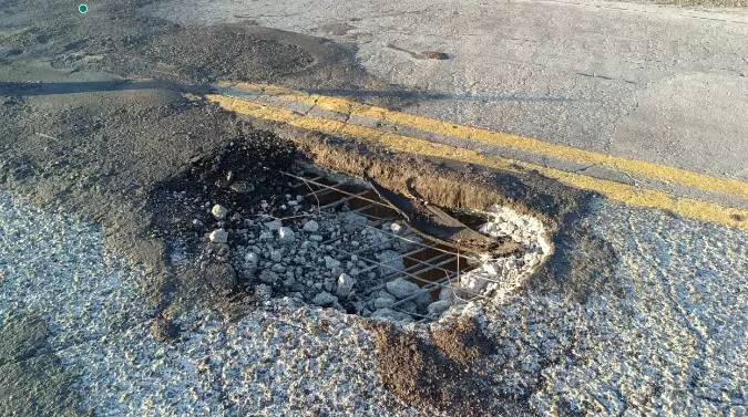 El agujero en el asfalto traspasa todo el pavimento dejando caer restos de cemento y piedras sobre la Ruta 84.