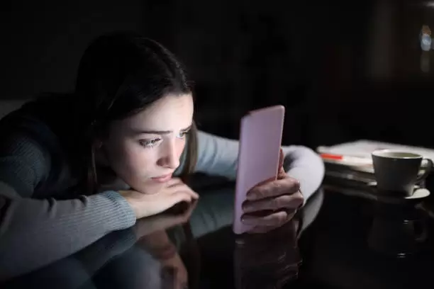 Persona mirando con tristeza su celular