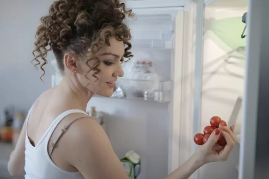 Mujer Sonriente Con Ramita De Uva Roja Madura En Cocina