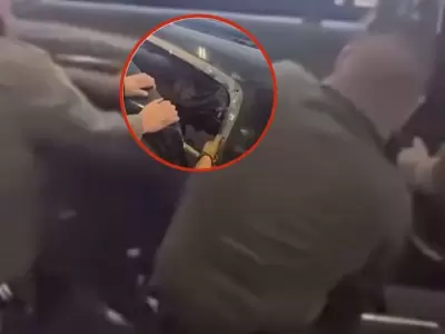 Autoridades de la frontera estadounidense en momentos en que retiran la chapa de la camioneta.