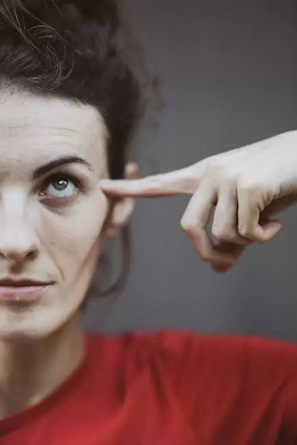 Foto De Retrato De Enfoque Selectivo De Mujer En Camiseta Roja Apuntando A Su Cabeza