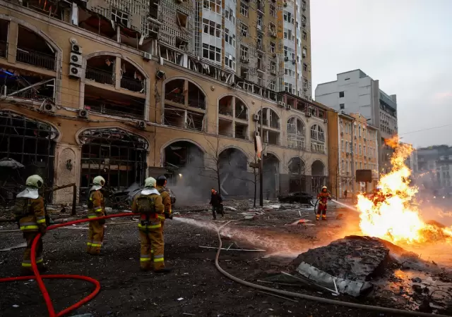 Bomberos apagan el fuego tras un ataque ruso este viernes en Kiev.