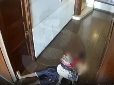 La v�ctima, tendida en el piso, y el ladr�n rob�ndole.