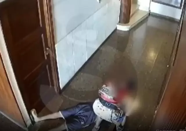 La v�ctima, tendida en el piso, y el ladr�n rob�ndole.