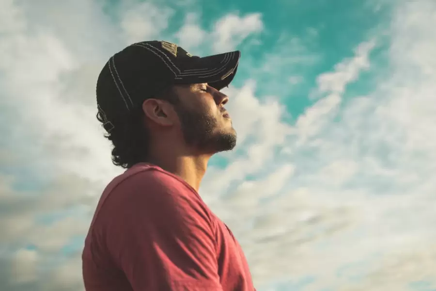 Hombre Vestido Con Gorra Negra Con Los Ojos Cerrados Bajo El Cielo Nublado