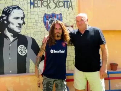 H�ctor Scotta junto al historiador cuervo Victor Pradel, en un mural en la entrada de su casa junto a unos asientos del Viejo Gas�metro.