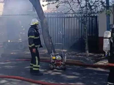 Bomberos trabajando a destajo para sofocar las llamas.