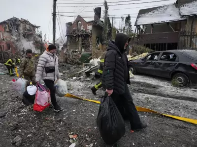 Residentes abandonan sus hogares con sus pertenencias tras un ataque de drones ruso que da�� edificios en Kiev.
